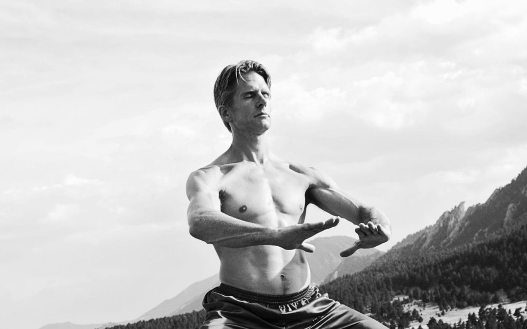 David J. coon practicing Qigong on a rock