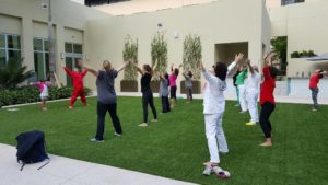In this photo Qigong Awareness students are performing Qigong Exercises during a workshop in West Palm Beach, FL on the grass near the pool.