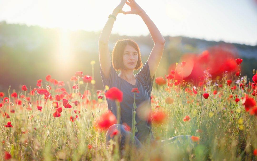 Woman practicing Qigong in Field of Beautiful Red Flowers