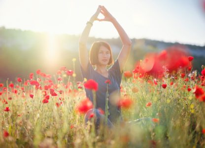 Woman practicing Qigong in Field of Beautiful Red Flowers