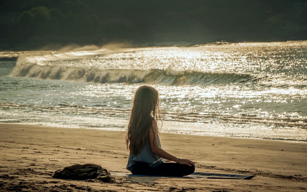 Girl meditating on beach