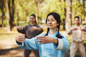 group of women practicing qigong in the forest