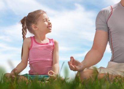 a child and parent meditating together