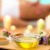 Spa oils displayed in bowls on a tray with flowers.