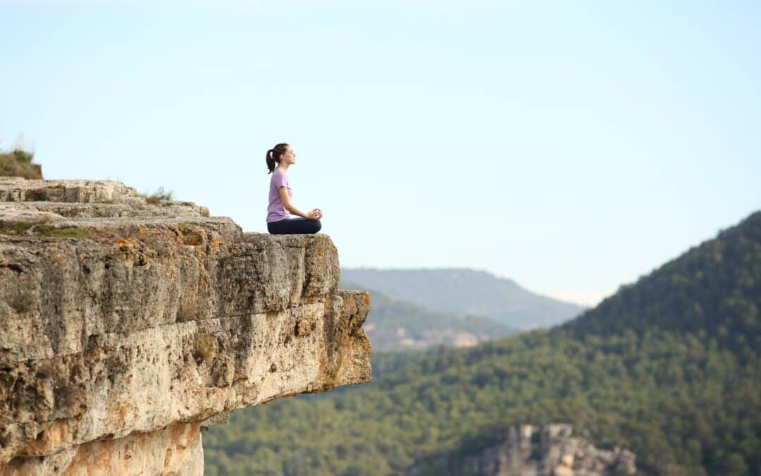 Woman practicing seated meditation with mountains in the background
