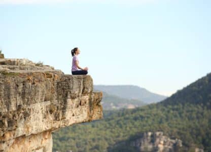 Woman practicing seated meditation with mountains in the background