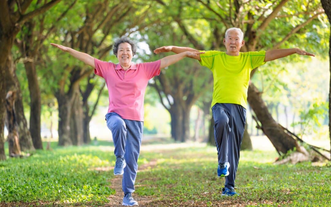 two older adults practicing qigong with smiles