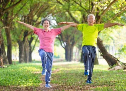 two older adults practicing qigong with smiles