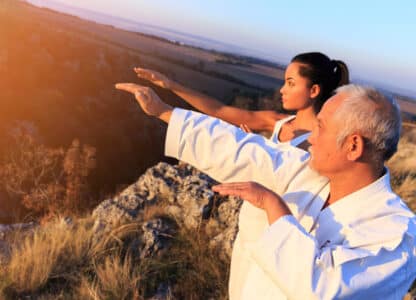 Senior man teaching young woman Qigong. Online CEU Course with David J. Coon