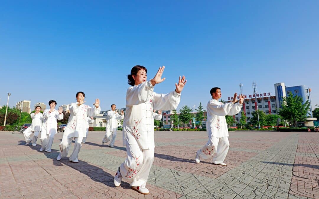 group Qigong energy practice outside in white garb