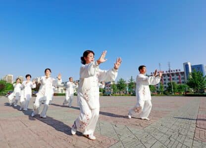 group Qigong energy practice outside in white garb