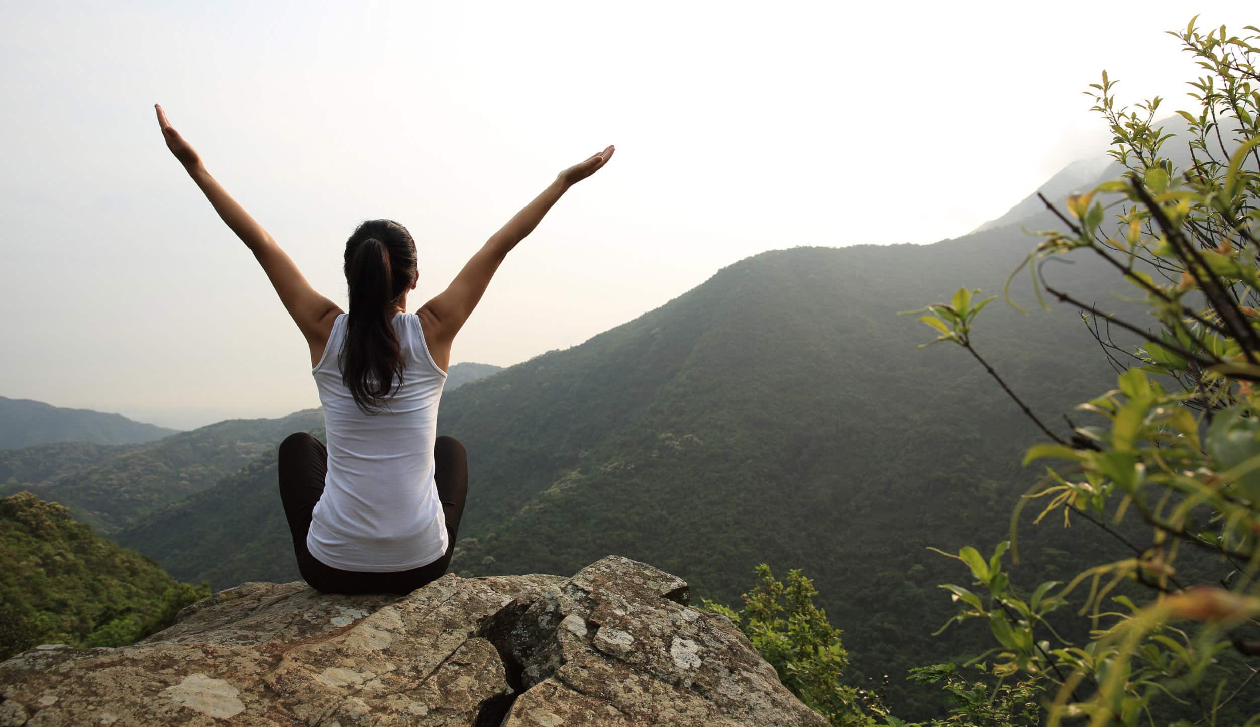 woman practicing qigong celebration with a mountain view