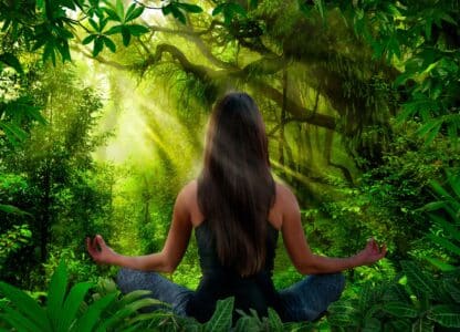 woman practicing qigong or yoga in a jungle setting